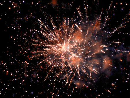 Vibrant bursts of orange and white illuminate the night, trailing shimmering sparks that evoke excitement and joy, perfect for capturing a festive mood.の写真素材