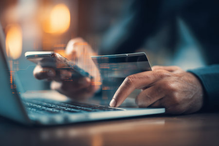 A user completes a protected digital transaction, holding a smartphone and credit card amid a laptop and streamlined interface, embodied modern fintech security.の写真素材