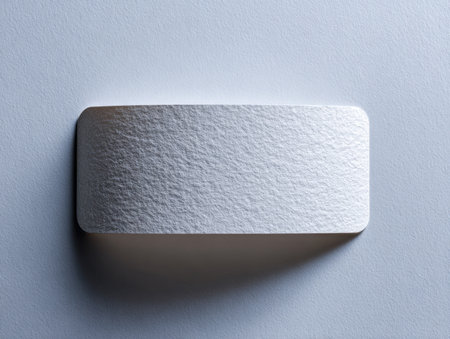 A clean, textured white card positioned on a sleek gray background, gently shadowed to highlight simplicity?perfect for modern branding or minimalistic visuals.の写真素材