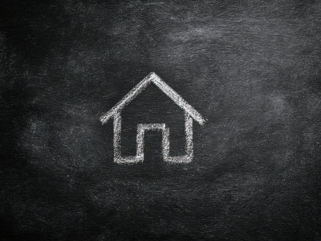 A minimalistic white chalk sketch of a house icon on a dark background, conveying ideas of home, simplicity with ample empty space around.の写真素材