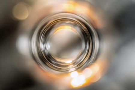 A mesmerizing interplay of light and color, featuring shimmering reflections and gentle glowing orbs captured through a sleek, curved glass surface, evoking a dreamyの写真素材