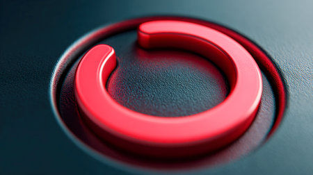A vivid crimson glow radiates from a circular symbol on a rough black background, embodying themes of digital control, device startup, and technological energy.の写真素材