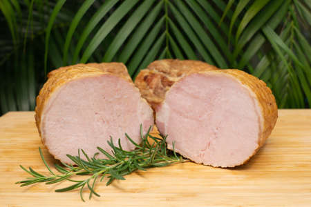 Smoked pork ham with rosemary. Cold cuts on wooden boardの写真素材