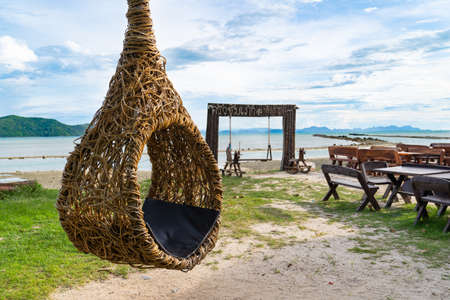 Round Swing on on a sandy beach with sea water backgroundの写真素材