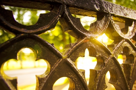 Christian architecture, old antique fence of church with cross cuts and bright light from back
の写真素材