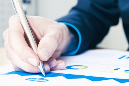 Close-up of making notes to sales reportの写真素材