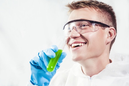 Chemist smiling confidently and testing experimentの写真素材