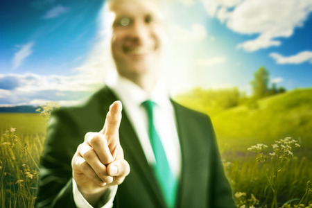 Business man pointing virtual interface nature conceptの写真素材