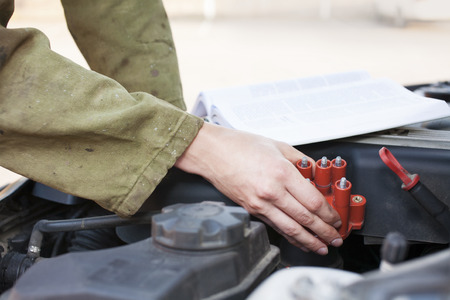 Mechanic reading instructions manual and replacing broken partの写真素材