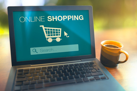 Online shopping searching products from internet with laptop on tableの写真素材