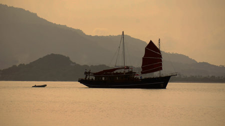 Late evening fishing schooner comes to fishing to the islands