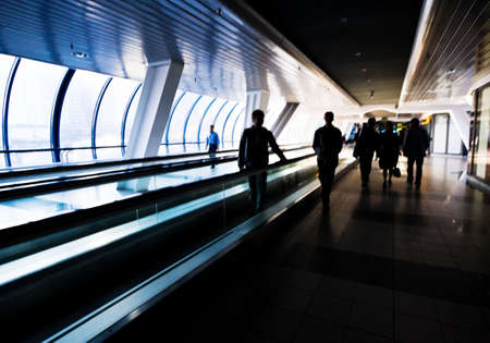 Hight contrast picture of several people (silhouettes) walking in a corridorの写真素材