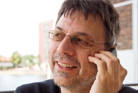 Close-up portrait of a mature man speaking on cellphone