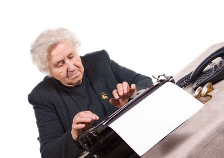 old woman typing on old typewriter, isolated on whiteの写真素材