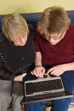 Grandmother and grandson working together with laptop 