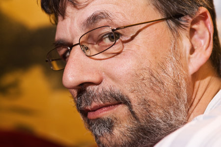 Closeup portrait of a mature man turned to photographer