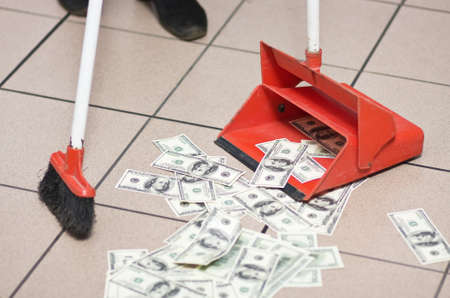 Hundred dollar notes strewed on the flloor and cleaned by broom and dust-panの写真素材