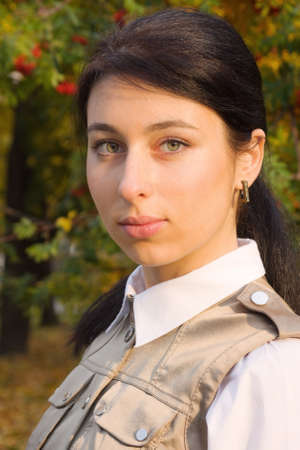 Pretty brunette girl in an autumn parkの写真素材