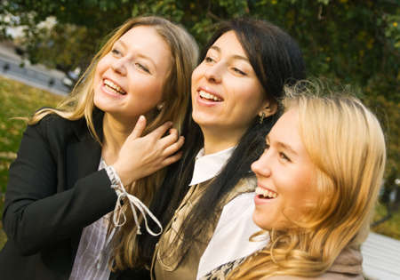Three laughing girls captured outdoors; selective focusの写真素材
