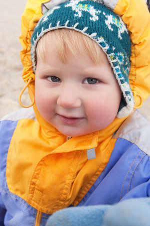 Little boy on a walk in warm winter clothes
