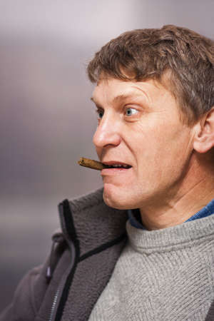 Mature man with cigar surprised by somethingの写真素材