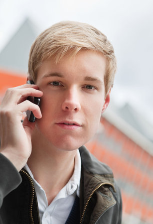 Young handsome man speaking on cellphone outdoors