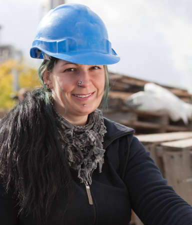 Portrait of a smiling female worker in blue hard hatの写真素材