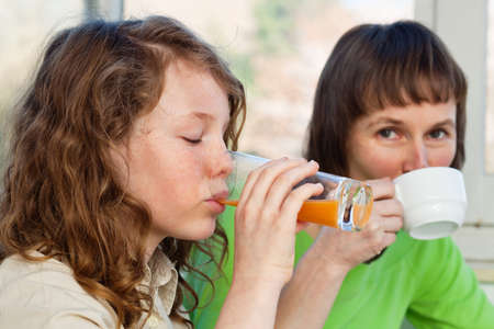 Daughter and her mom having a breakfast togetherの写真素材