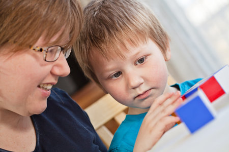 Mother and her little son playing colorful toys at home