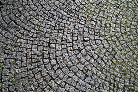 Closeup view on a cobblestone road - pattern - background - contrasty due to a side sunlightの写真素材