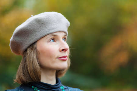 Outdoor portrait of cheerful middle aged woman wearing grey beretの写真素材