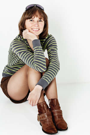 Smiling middle aged woman sitting on the floor の写真素材