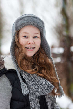 Outdoor portrait of a cheerful teenager girl in winter clothsの写真素材