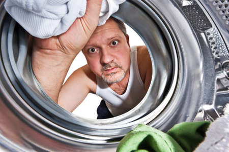 Man loading cloths to washing machine. View from inside the washing machine.の写真素材