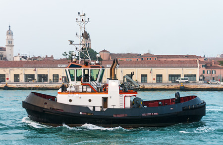 Tug boat in front of the old port terminal in Venice, Italyの写真素材