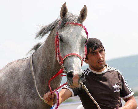 PYATIGORSK, RUSSIA - AUGUST 21: An unidentified groom and arabian horse, grey mare Pirma after race for the prize of Bolshoi Sprinterski on August 21,2011 in Pyatigorsk, Caucasus, Russia. のeditorial素材