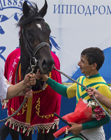 PYATIGORSK,RUSSIA - JULY 23,2017:The winners of the "Derby",traditional prize is a purebred english stallion Gosudar and jockey Islam Pshukov - on a racetrack in Pyatigorsk,Caucasus,Russia.のeditorial素材