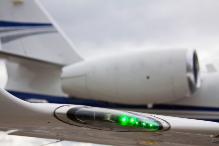wing with lights and engine private plane against cloudy skyのeditorial素材