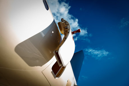 open door and tail in private jet against the blue sky