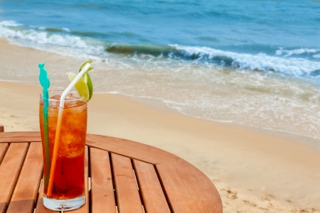 Americano cocktail with ice on the table against the background of sea and skyの写真素材