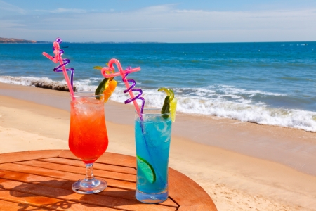 Sunrise cocktail and cocktail blue lagoon on the table on the background of blue sea and skyの写真素材