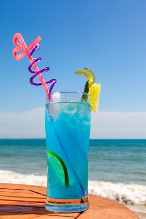cocktail blue lagoon on the table on the background of blue sea and skyの写真素材