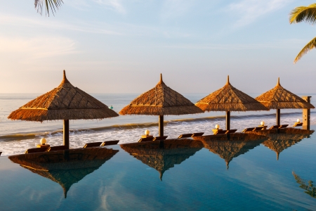 pool and umbrellas on the background of the sea and sky at dawnの写真素材