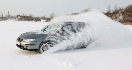 extreme driving, the car is moving rapidly over the smooth snow and creates a spray of snowの写真素材