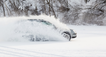 extreme driving, the car is moving rapidly over the smooth snow and creates a spray of snowの写真素材