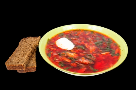 rye bread and a plate with fresh hot borsch isolated on a black backgroundの写真素材