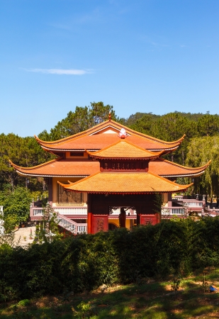 Buddhist temple Vietnam through the trees on a background of blue skyのeditorial素材