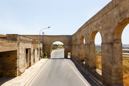 Aqueduct Victoria in Gozo, maltese landscape with the yellow field and blue sky background, Malta, Gozo islandの写真素材