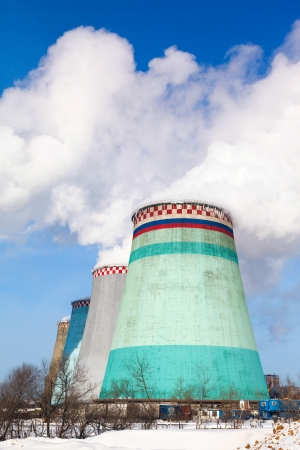 Smoking pipes of thermal power plant against blue skyの写真素材