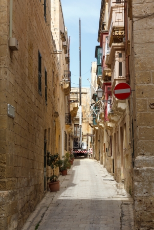 construction crane on the Maltese narrow street Vittoriosaの写真素材